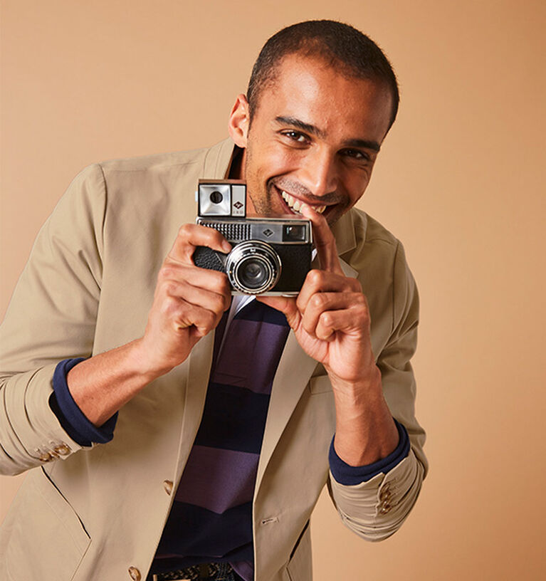 Man holding camera whilst wearing a blazer